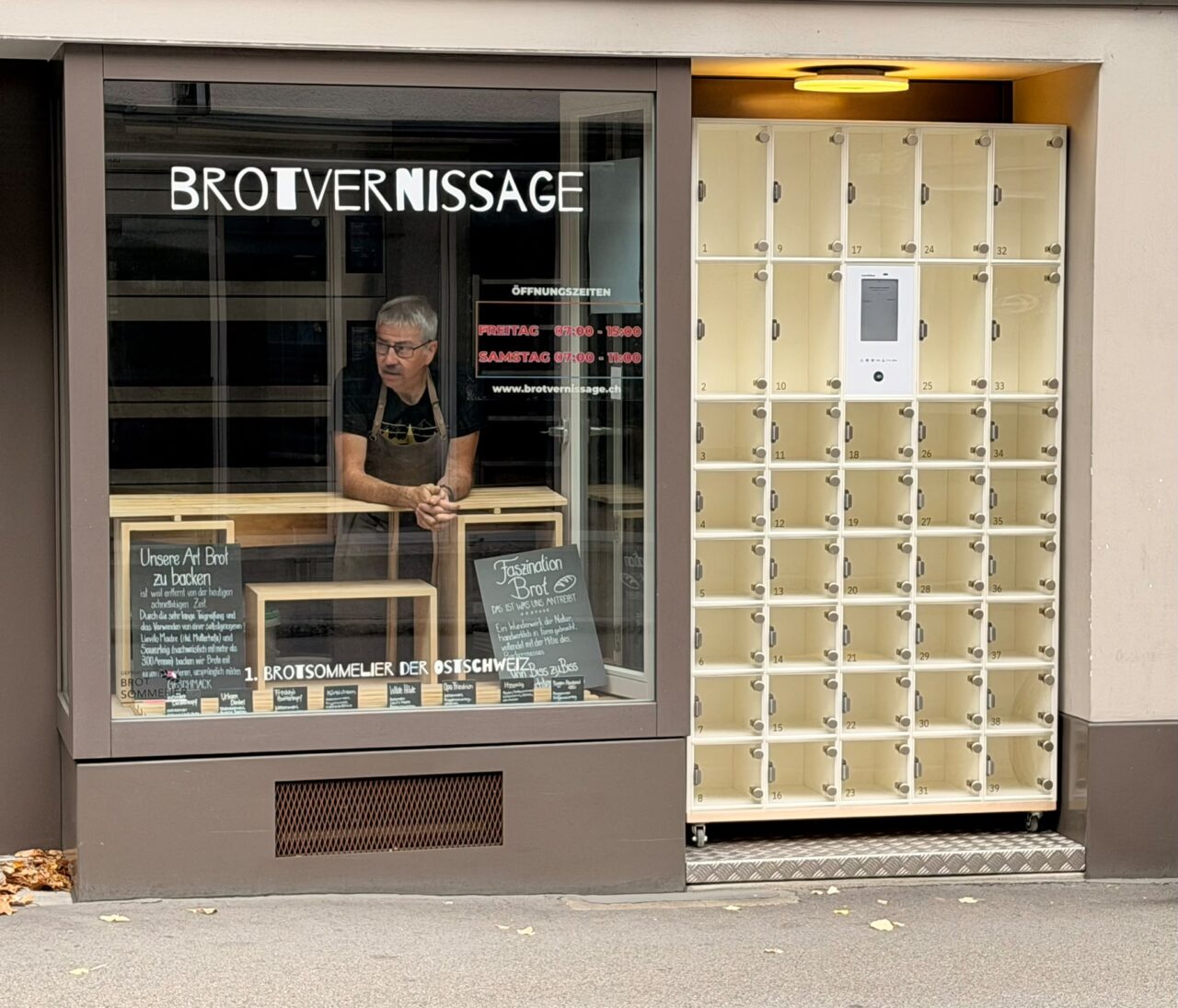 Alfred Bau am Fenster der Brotvernissage, direkt daneben die Brotbox mit ihren Abholfächern.